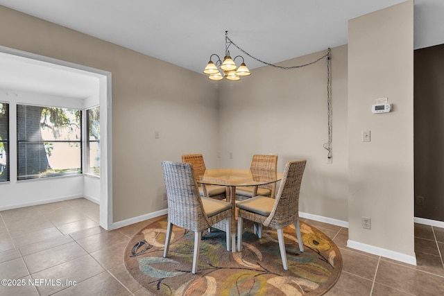 dining area with tile patterned flooring, baseboards, and a chandelier