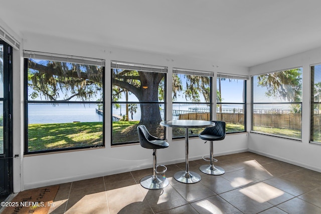 sunroom / solarium featuring plenty of natural light and a water view