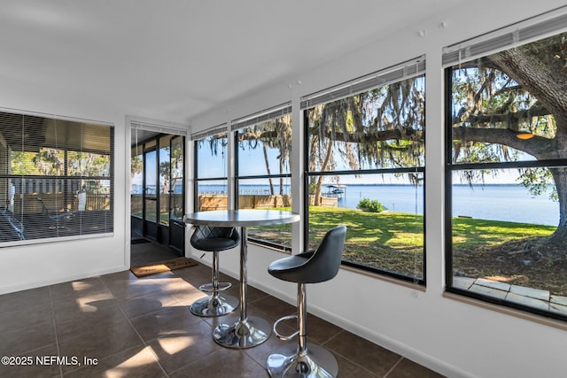 unfurnished sunroom featuring a healthy amount of sunlight and a water view