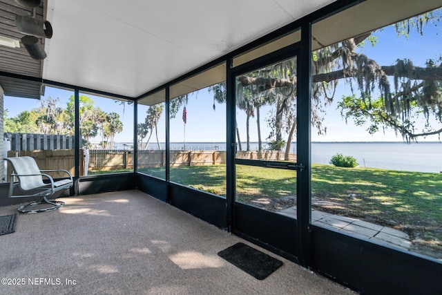 unfurnished sunroom featuring a water view