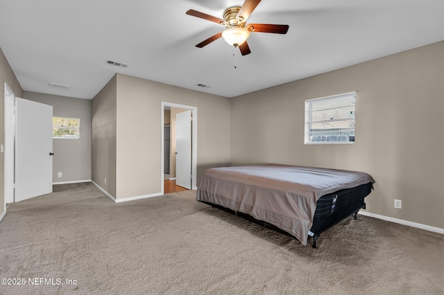 carpeted bedroom featuring visible vents, baseboards, and ceiling fan