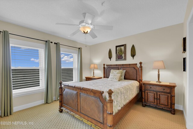 bedroom with a ceiling fan, baseboards, and a textured ceiling