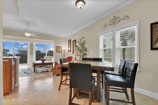 dining area featuring light tile patterned floors, a healthy amount of sunlight, baseboards, and ornamental molding