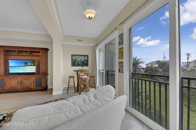 living area with light tile patterned flooring, baseboards, and visible vents