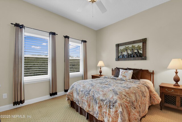 bedroom featuring baseboards, light carpet, and ceiling fan