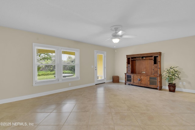 unfurnished room featuring light tile patterned floors, a ceiling fan, and baseboards