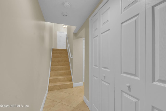 stairway featuring tile patterned floors and baseboards