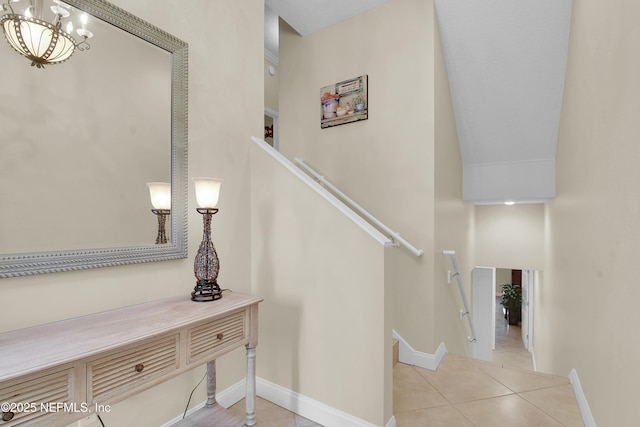 stairs featuring baseboards, a chandelier, and tile patterned flooring