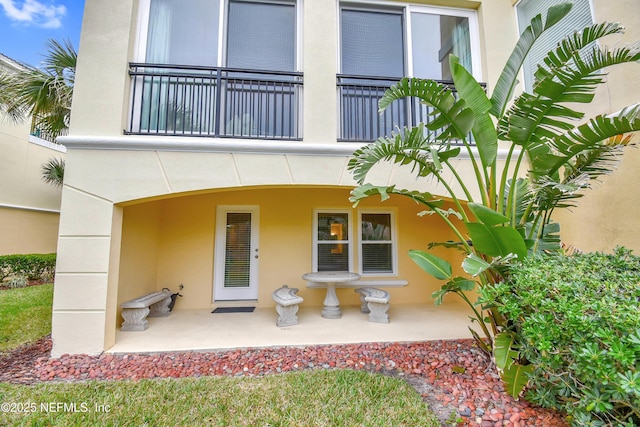 exterior space featuring stucco siding and a balcony