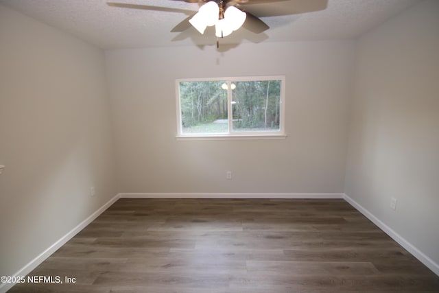 empty room with ceiling fan, a textured ceiling, baseboards, and wood finished floors