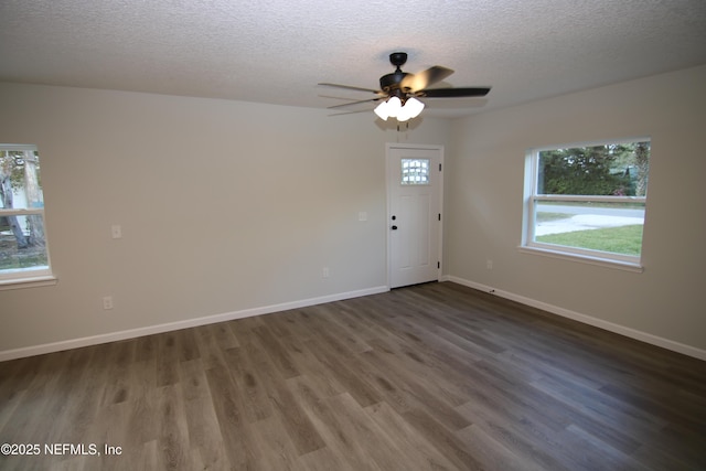 unfurnished room with plenty of natural light, wood finished floors, and baseboards