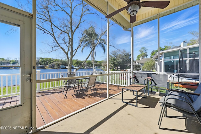 sunroom featuring a water view and ceiling fan