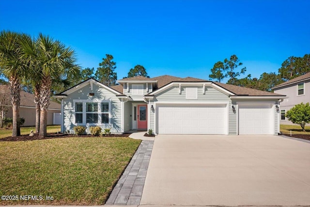 view of front of house featuring a front lawn, an attached garage, and driveway