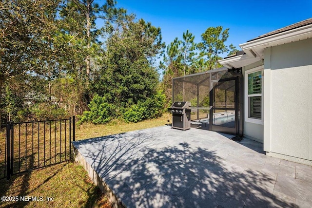 view of patio / terrace with a lanai, fence, and grilling area