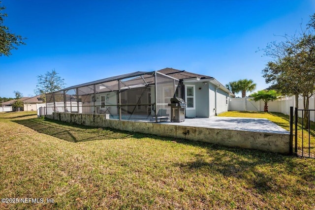 back of property with glass enclosure, a fenced backyard, stucco siding, a patio area, and a lawn