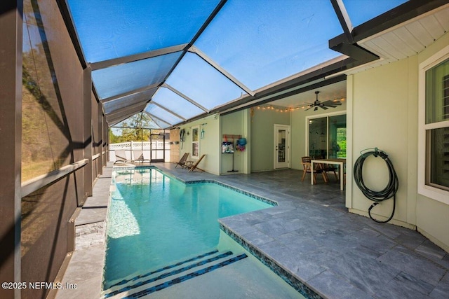 view of swimming pool with glass enclosure, fence, a fenced in pool, ceiling fan, and a patio area