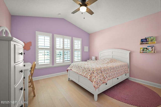 bedroom with a ceiling fan, lofted ceiling, baseboards, and light wood-type flooring