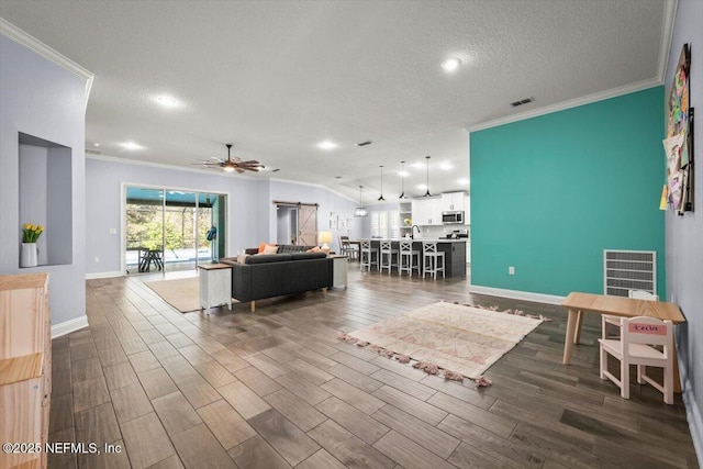 living area featuring crown molding, dark wood-style floors, visible vents, and ceiling fan