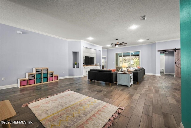 living area with visible vents, dark wood-type flooring, baseboards, a barn door, and a ceiling fan