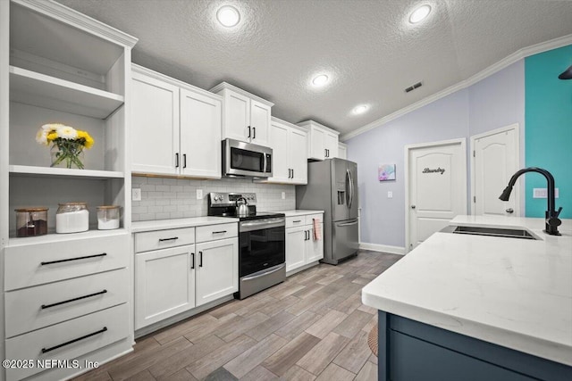 kitchen with visible vents, lofted ceiling, open shelves, a sink, and appliances with stainless steel finishes