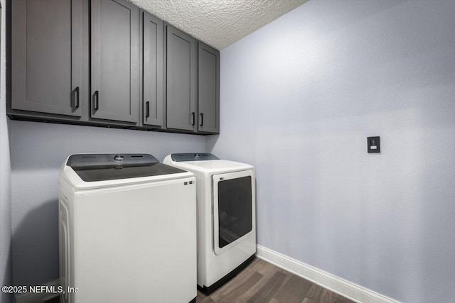 laundry room with independent washer and dryer, a textured ceiling, dark wood finished floors, cabinet space, and baseboards