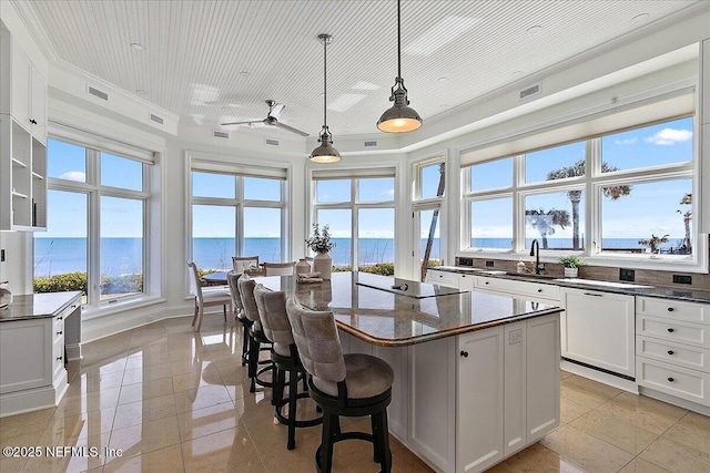 kitchen with visible vents, white cabinets, a center island, and black electric stovetop