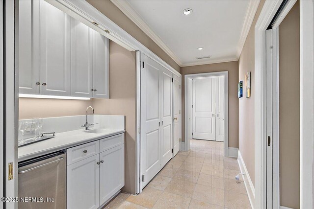 kitchen with visible vents, crown molding, baseboards, light countertops, and stainless steel dishwasher