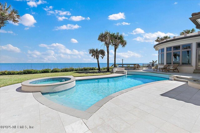 view of pool featuring a pool with connected hot tub, a patio, and a water view