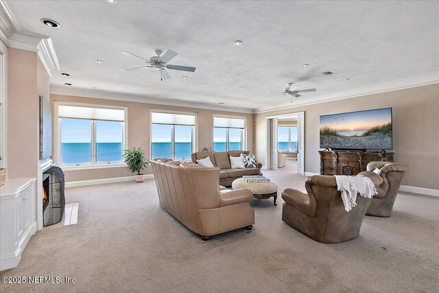 living area with plenty of natural light, light colored carpet, and ornamental molding