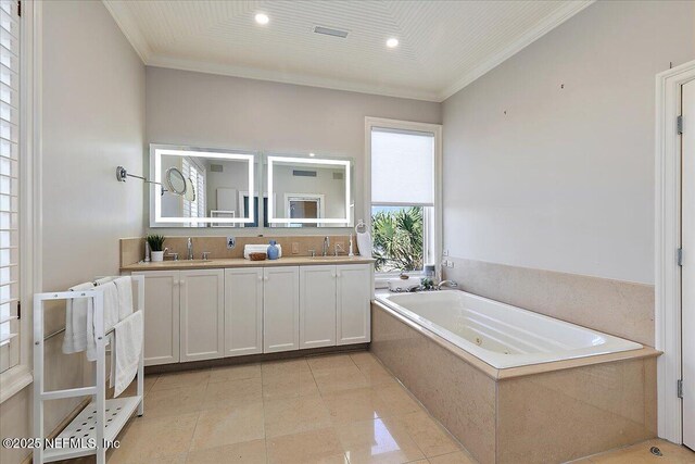 bathroom featuring a sink, a whirlpool tub, double vanity, and crown molding