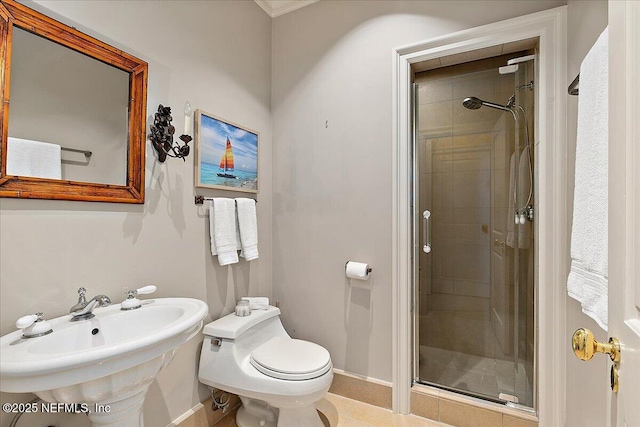 full bathroom with toilet, baseboards, a stall shower, and a sink