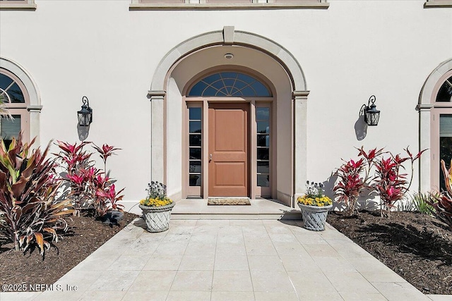 doorway to property featuring stucco siding