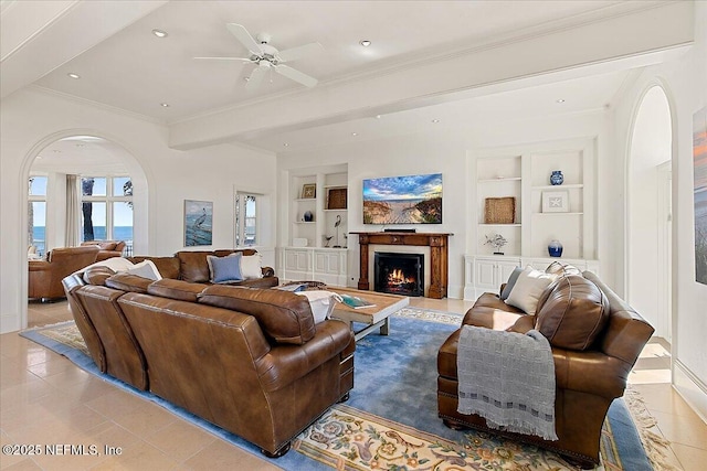 living area with built in shelves, arched walkways, and light tile patterned flooring