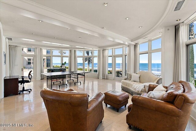 living room with plenty of natural light, crown molding, and a water view