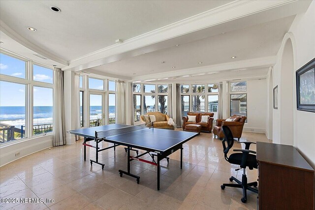 game room featuring light tile patterned floors, baseboards, recessed lighting, ornamental molding, and a water view