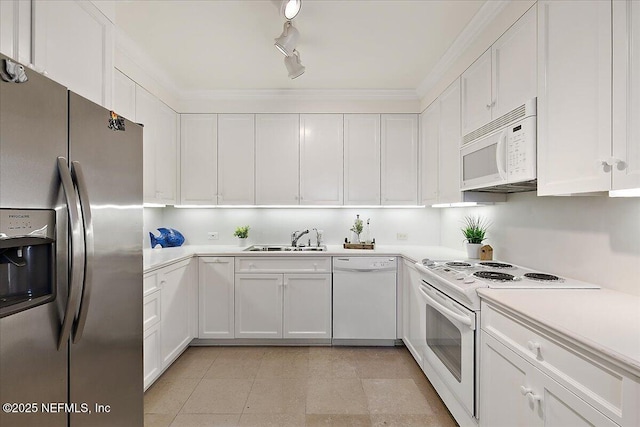 kitchen with track lighting, a sink, white appliances, white cabinets, and light countertops