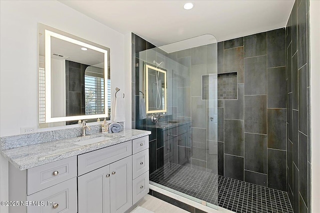 full bath featuring recessed lighting, visible vents, tiled shower, and vanity