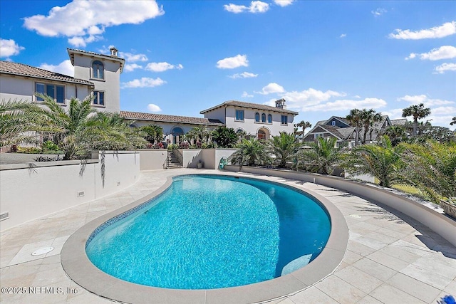 view of swimming pool featuring a patio area, a fenced in pool, and fence