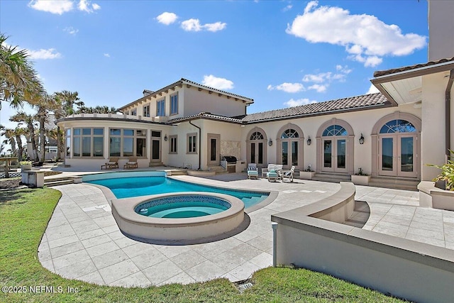 back of house with a tile roof, stucco siding, french doors, an in ground hot tub, and a patio