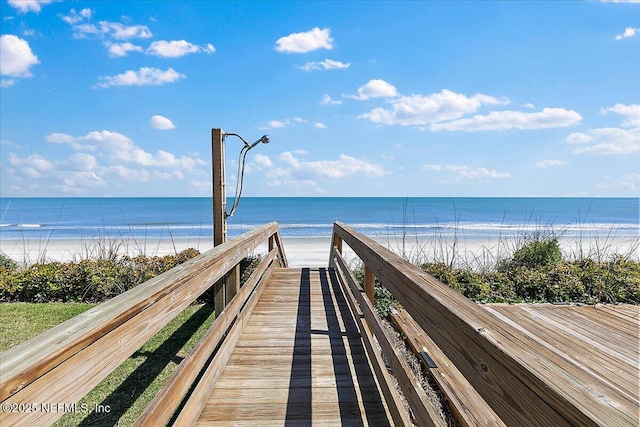 surrounding community with a water view and a beach view