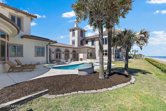 outdoor pool with a patio and a lawn