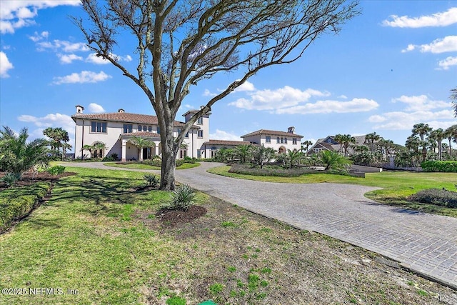 exterior space with a front lawn, decorative driveway, and stucco siding