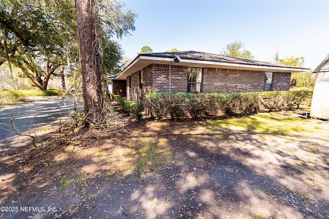 view of side of home featuring brick siding