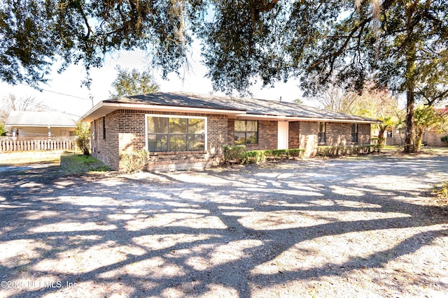 single story home featuring brick siding and fence