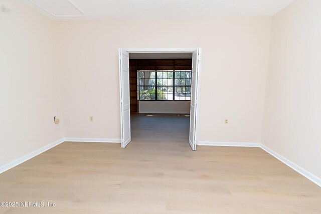 spare room with light wood-style flooring and baseboards