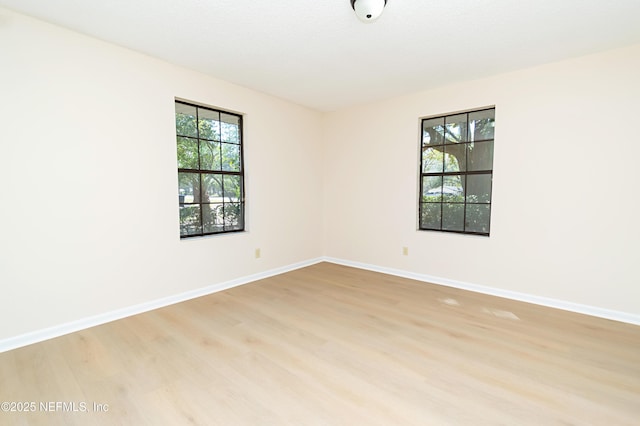 empty room with light wood-type flooring and baseboards