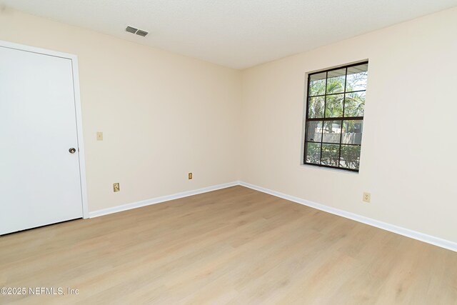 unfurnished room featuring visible vents, baseboards, and light wood-style floors