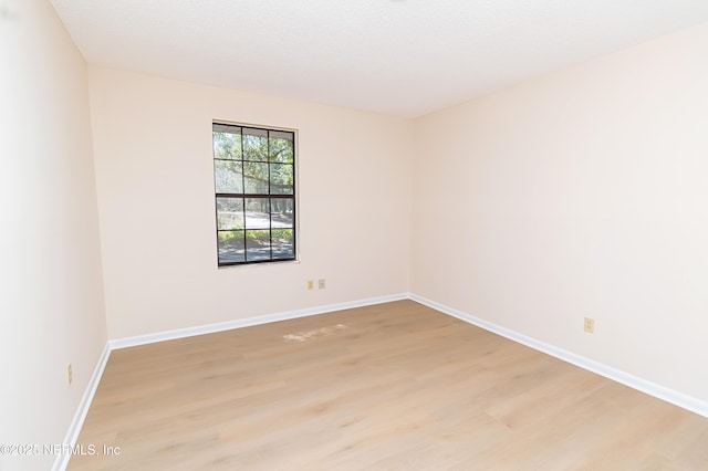 spare room with light wood-style floors and baseboards