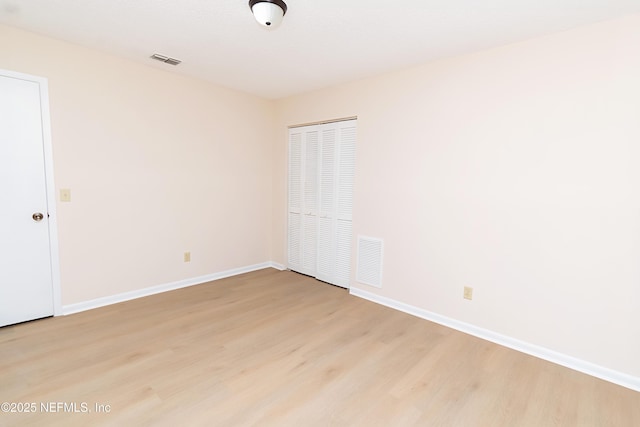 unfurnished room featuring visible vents, baseboards, and light wood-style floors