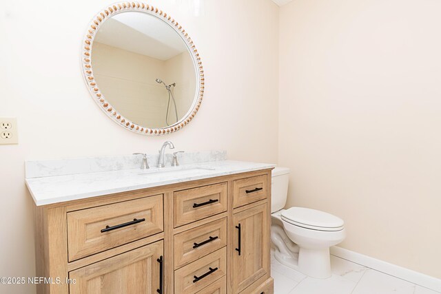 bathroom with marble finish floor, toilet, vanity, and baseboards